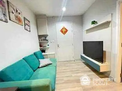 Cozy living room with teal sofa and wall-mounted TV in modern apartment.