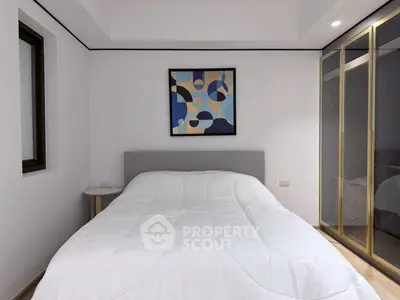 Modern bedroom with abstract art and mirrored wardrobe