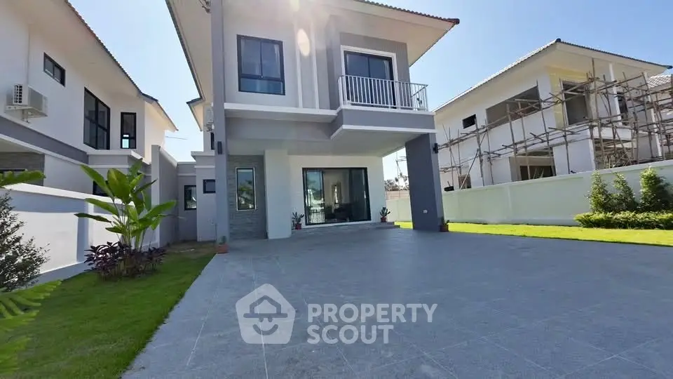Modern two-story house with spacious driveway and lush green lawn