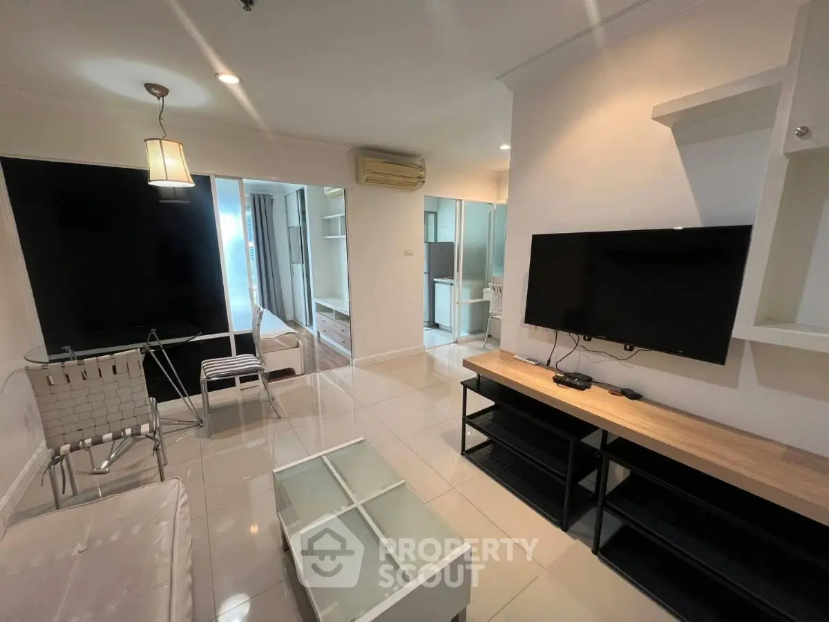 Modern living room with sleek furniture and large TV, perfect for relaxation.