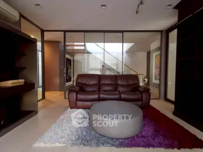 Modern living room with leather sofa and stylish decor in open-concept home.