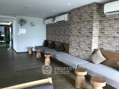 Stylish common area with brick accent wall and modern seating in a contemporary building.
