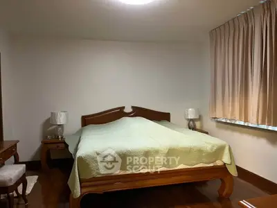Cozy bedroom with elegant wooden furniture and soft lighting, perfect for relaxation.