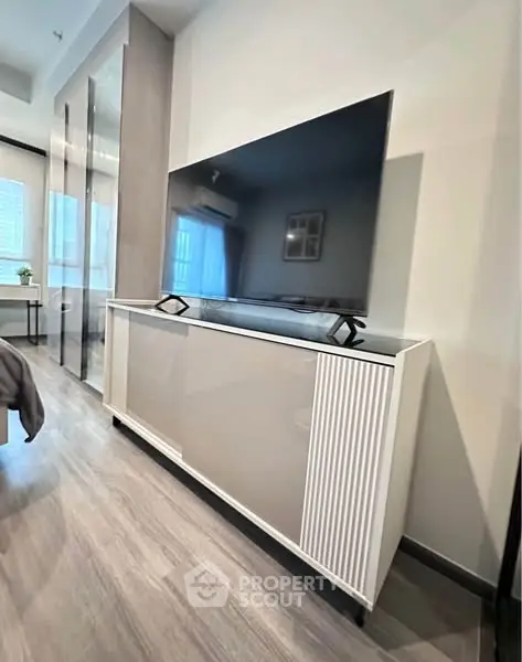 Modern living room with sleek TV stand and large flat-screen TV