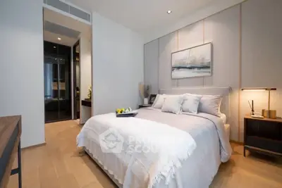 Elegant bedroom with modern decor and cozy ambiance, featuring a plush bed and stylish artwork.