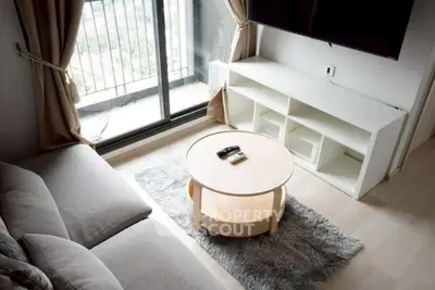 Cozy living room with balcony view, modern furniture, and natural light.
