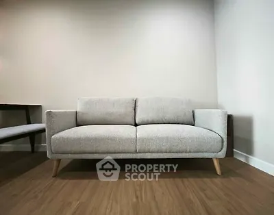 Modern minimalist living room with stylish gray sofa and wooden flooring