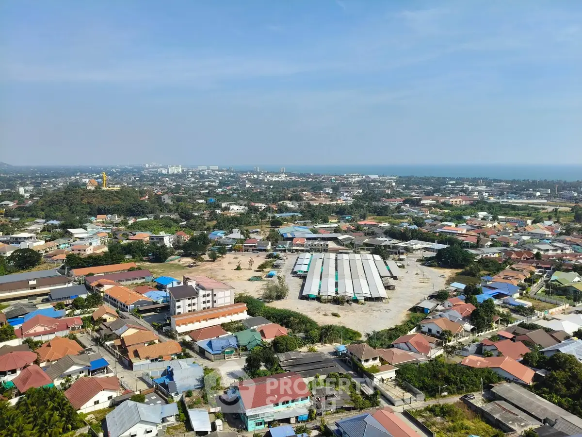 Aerial view of a suburban area with houses and open spaces near the coast.