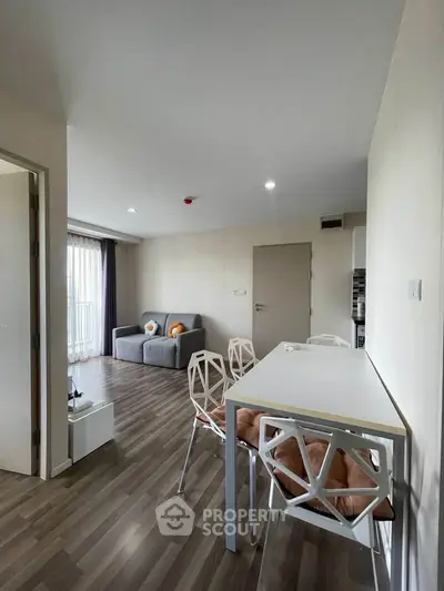Modern living room with stylish furniture and open layout, featuring a cozy sofa and dining area.