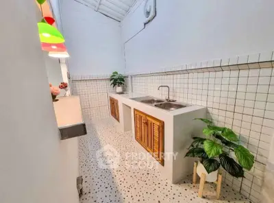 Charming kitchen with unique tile flooring and colorful pendant lights.