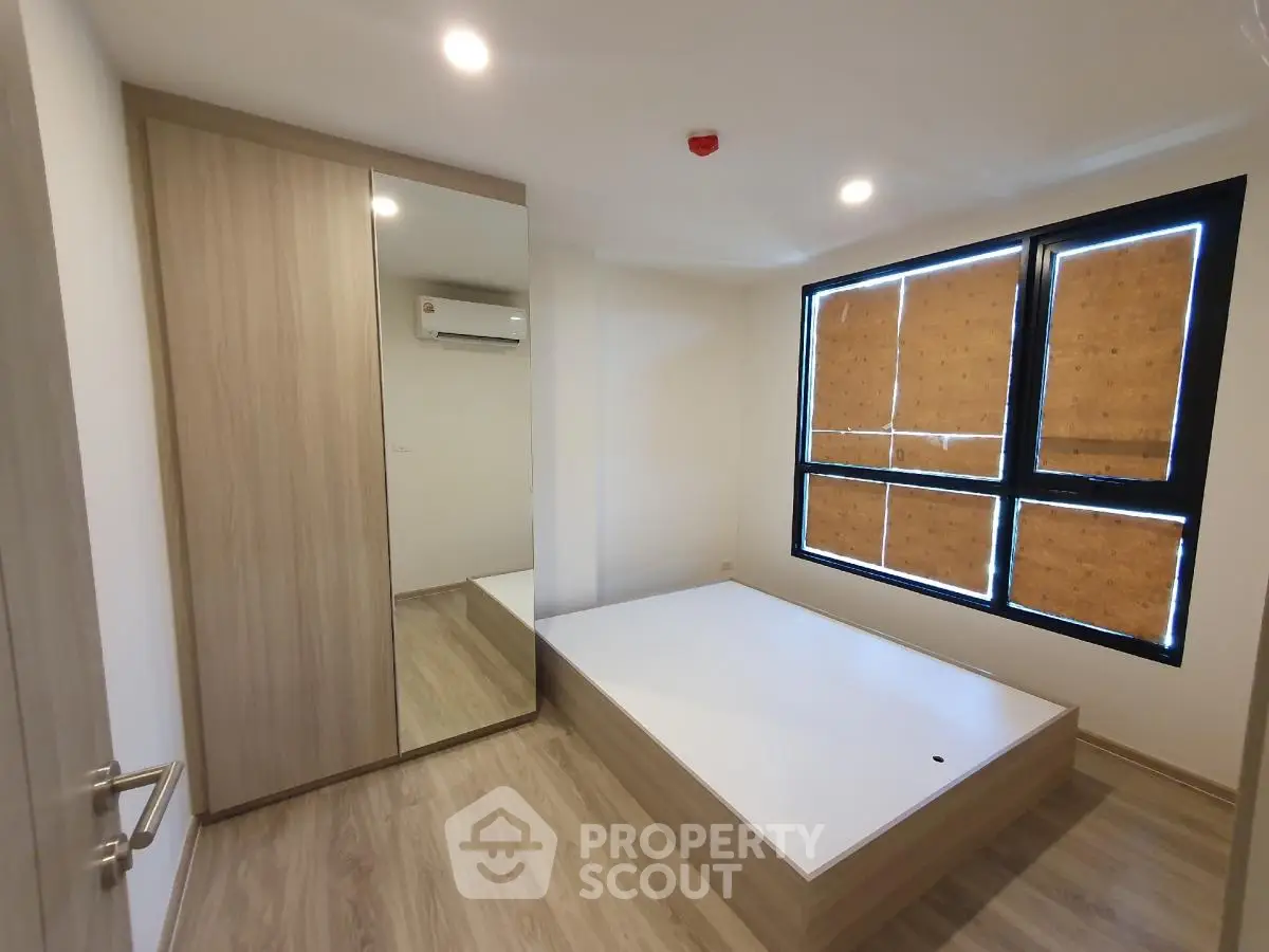 Modern bedroom with wooden flooring and built-in wardrobe