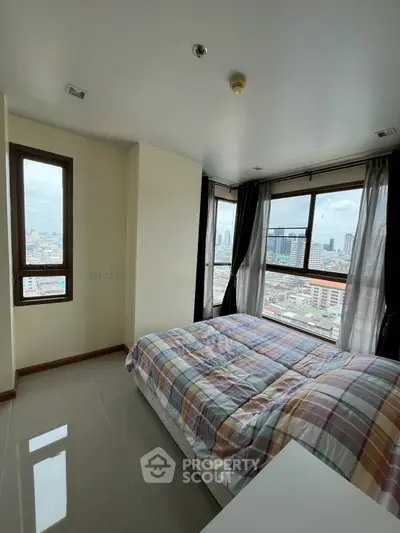 Spacious bedroom with city view and large windows in modern apartment