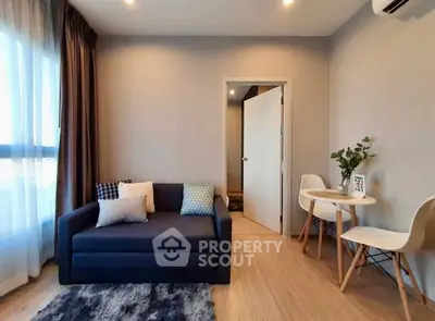 Modern living room with cozy sofa and dining area, featuring stylish decor and natural light.