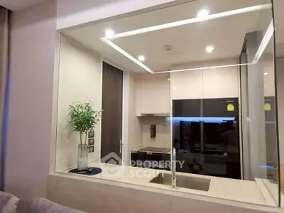 Modern kitchen with sleek design and open layout, featuring built-in appliances and stylish lighting.