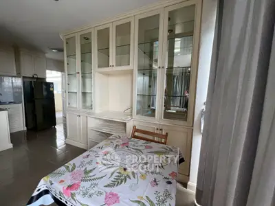 Charming kitchen with elegant cabinetry and floral tablecloth, perfect for cozy dining.