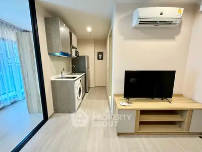 Modern apartment interior with open kitchen and living area, featuring sleek appliances and stylish decor.