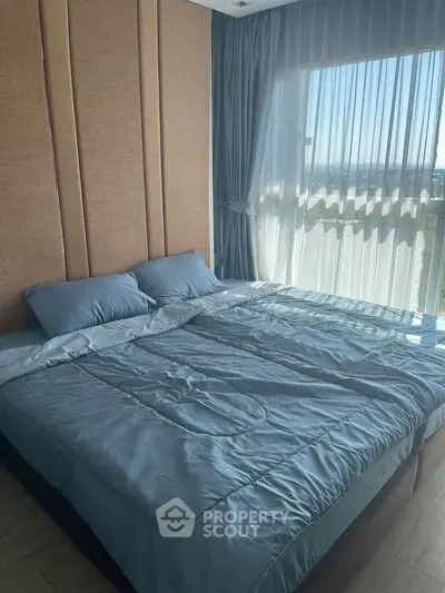 Spacious bedroom with large window offering stunning views and natural light.