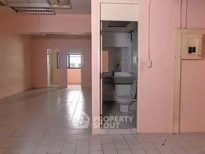 Spacious interior with tiled floors and bathroom, ideal for renovation.