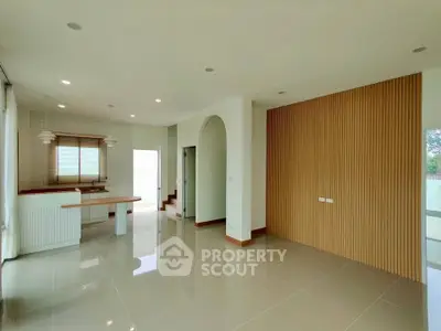 Modern open-plan living room with sleek kitchen and stylish wooden accents