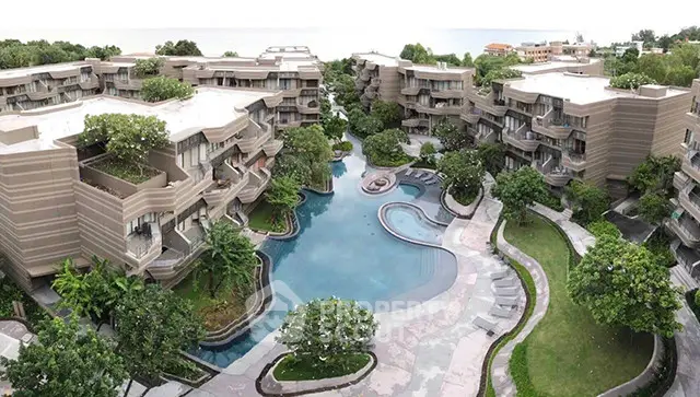 Luxurious resort-style condominium with stunning pool and lush greenery, offering serene living by the sea.