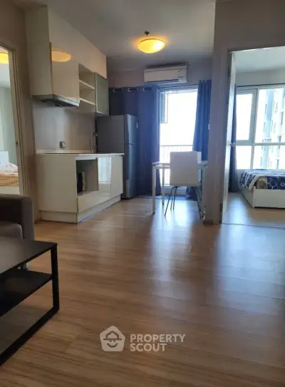 Modern apartment interior with open kitchen and cozy bedroom view.