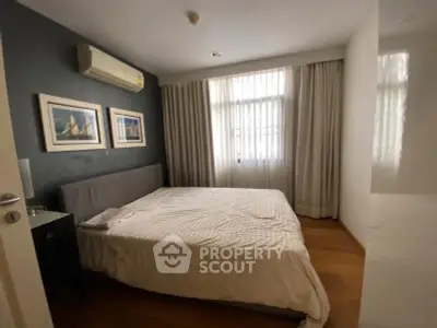Cozy bedroom with modern decor and natural light, featuring a comfortable bed and stylish artwork.