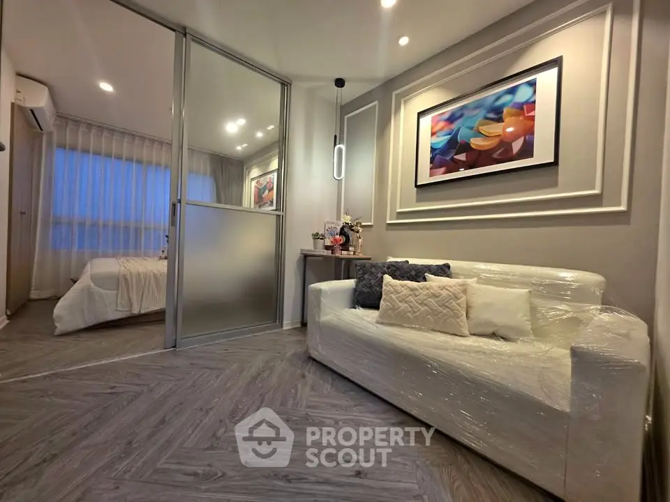 Modern living room with elegant decor and cozy ambiance, featuring a stylish sofa and artistic wall art.