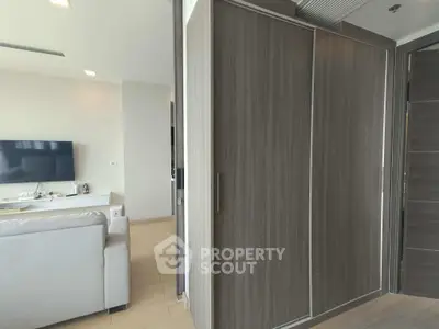 Modern living room with sleek wardrobe and flat-screen TV, showcasing contemporary interior design.