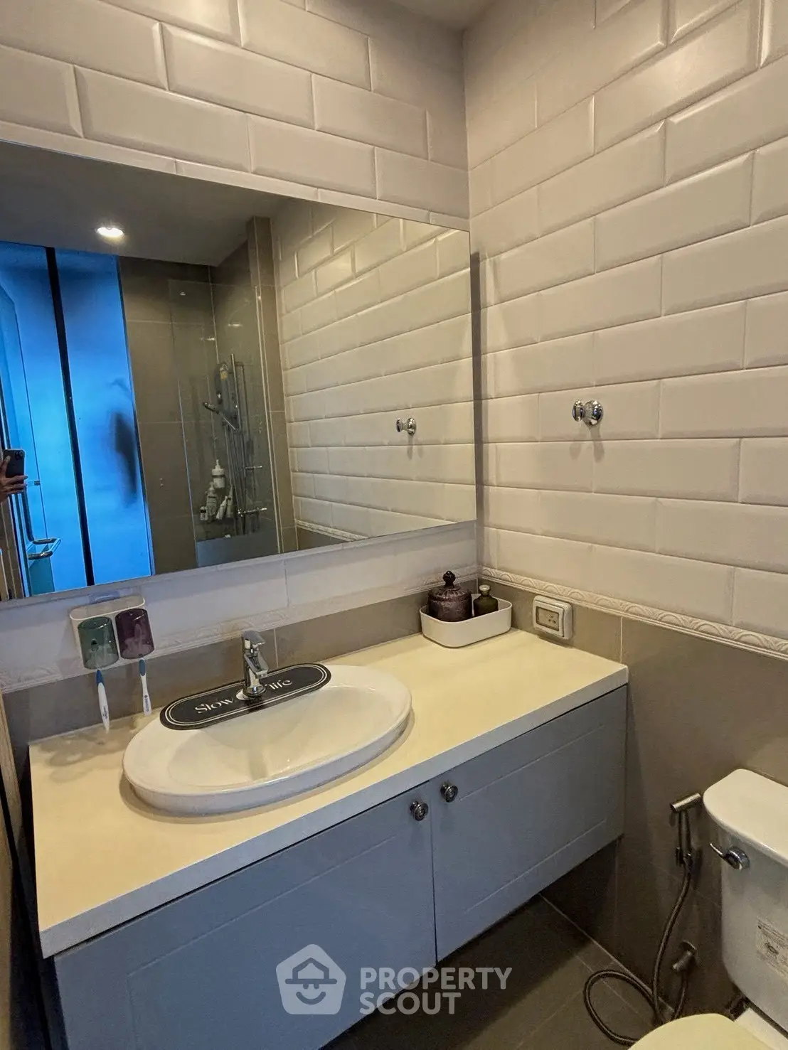 Modern bathroom with sleek vanity and large mirror in contemporary apartment.
