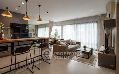 Modern open-plan living room with stylish kitchen and cozy seating area.