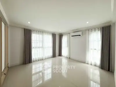 Spacious empty living room with large windows and air conditioning, perfect for customization.