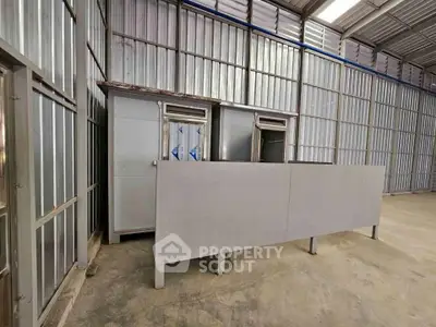 Spacious industrial warehouse interior with metal walls and concrete floor