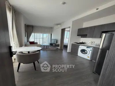 Modern apartment with open kitchen, washing machine, and bright living area with city view.