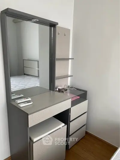 Modern bedroom with sleek vanity and ample storage space, perfect for stylish living.