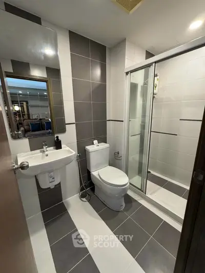 Modern bathroom with sleek design, featuring a glass shower enclosure and stylish fixtures.