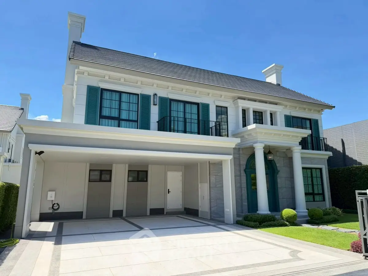 Elegant two-story house with classic architecture and spacious driveway, featuring lush green landscaping.