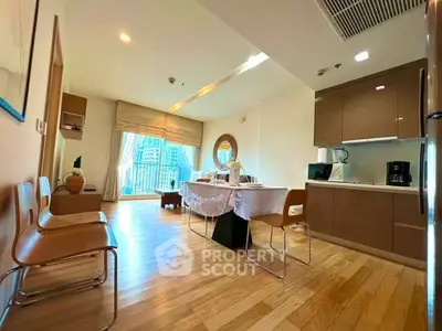Spacious modern living room with open kitchen and large windows offering city views.