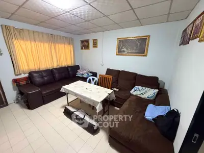 Cozy living room with brown sofas and a dining table, perfect for family gatherings.