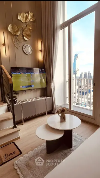 Modern living room with stylish decor and city view, featuring a TV and cozy seating area.