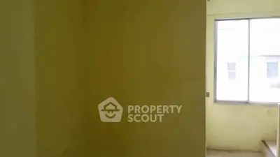 Spacious room with large window offering natural light and potential for customization.