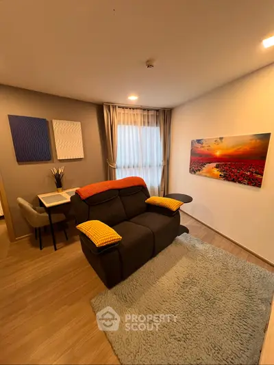 Cozy living room with modern decor and natural light, featuring a comfortable sofa and stylish artwork.