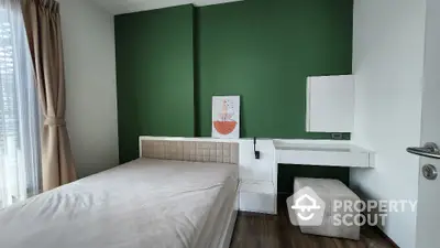 Modern bedroom with green accent wall and minimalist decor