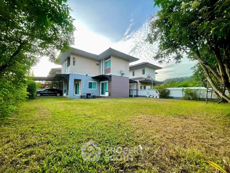 Spacious modern two-story house with lush garden and carport in serene neighborhood.