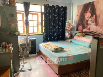 Cozy bedroom with large window, vibrant decor, and ample natural light.