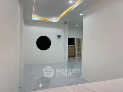 Modern minimalist interior with circular window and recessed lighting