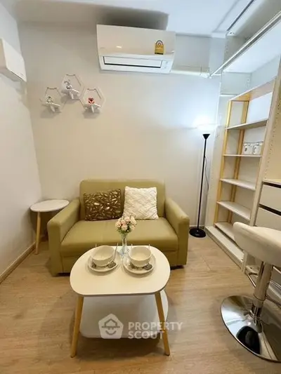 Cozy living room with modern decor and air conditioning, perfect for relaxation.