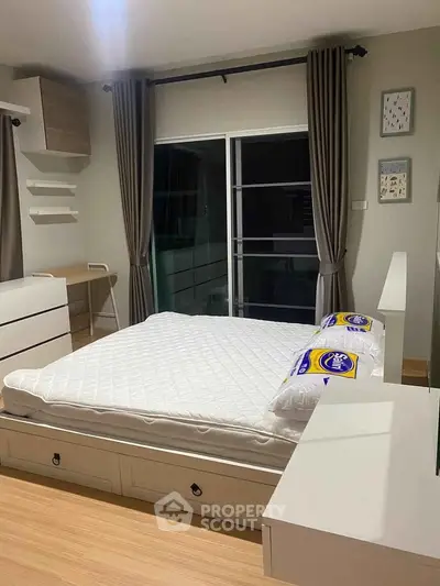 Modern bedroom with stylish decor and large window, featuring a comfortable bed and sleek furniture.