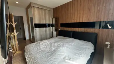 Modern bedroom with wooden accents and sleek design, featuring a cozy bed and ample storage space.