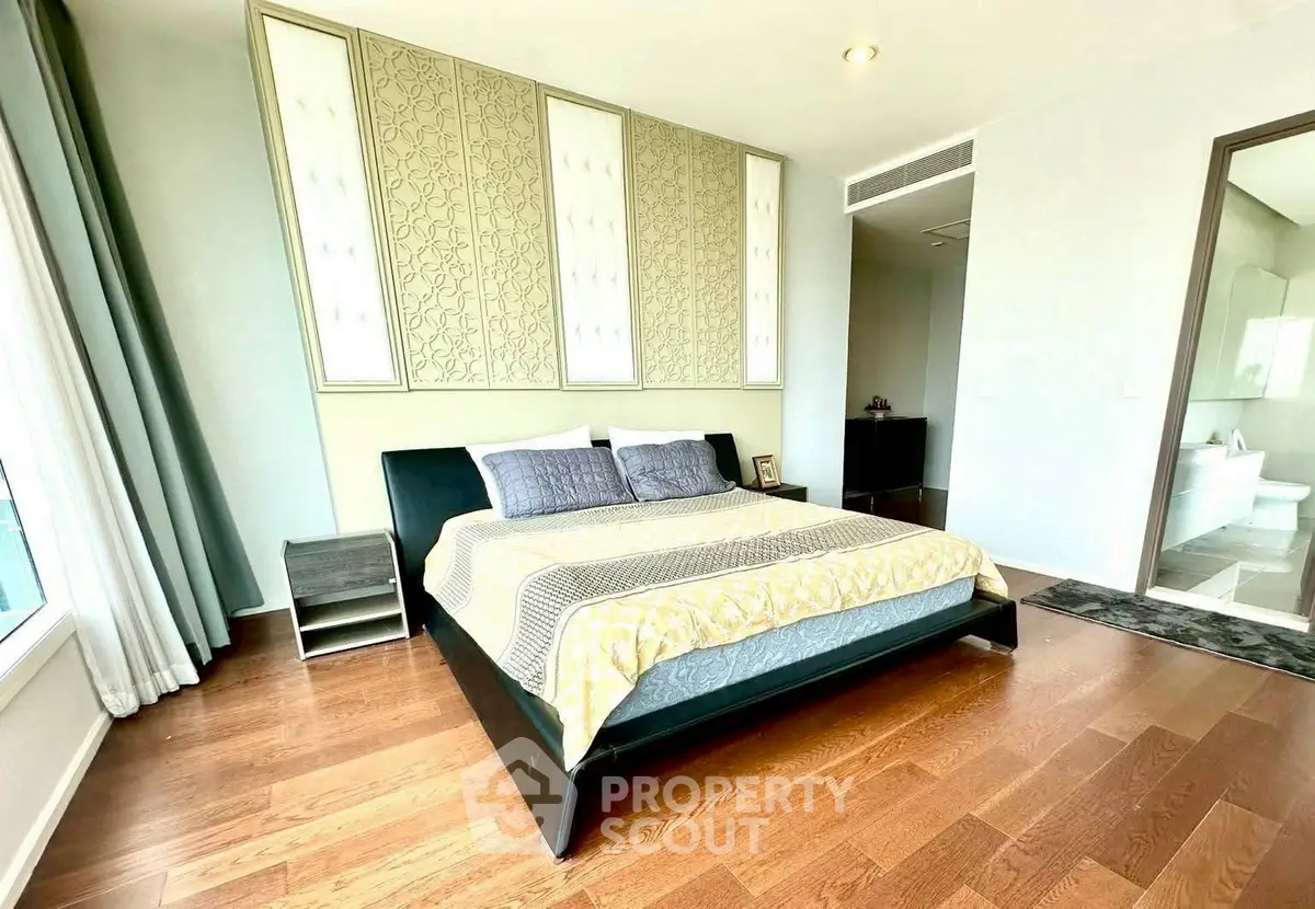 Spacious bedroom with elegant decor and hardwood flooring