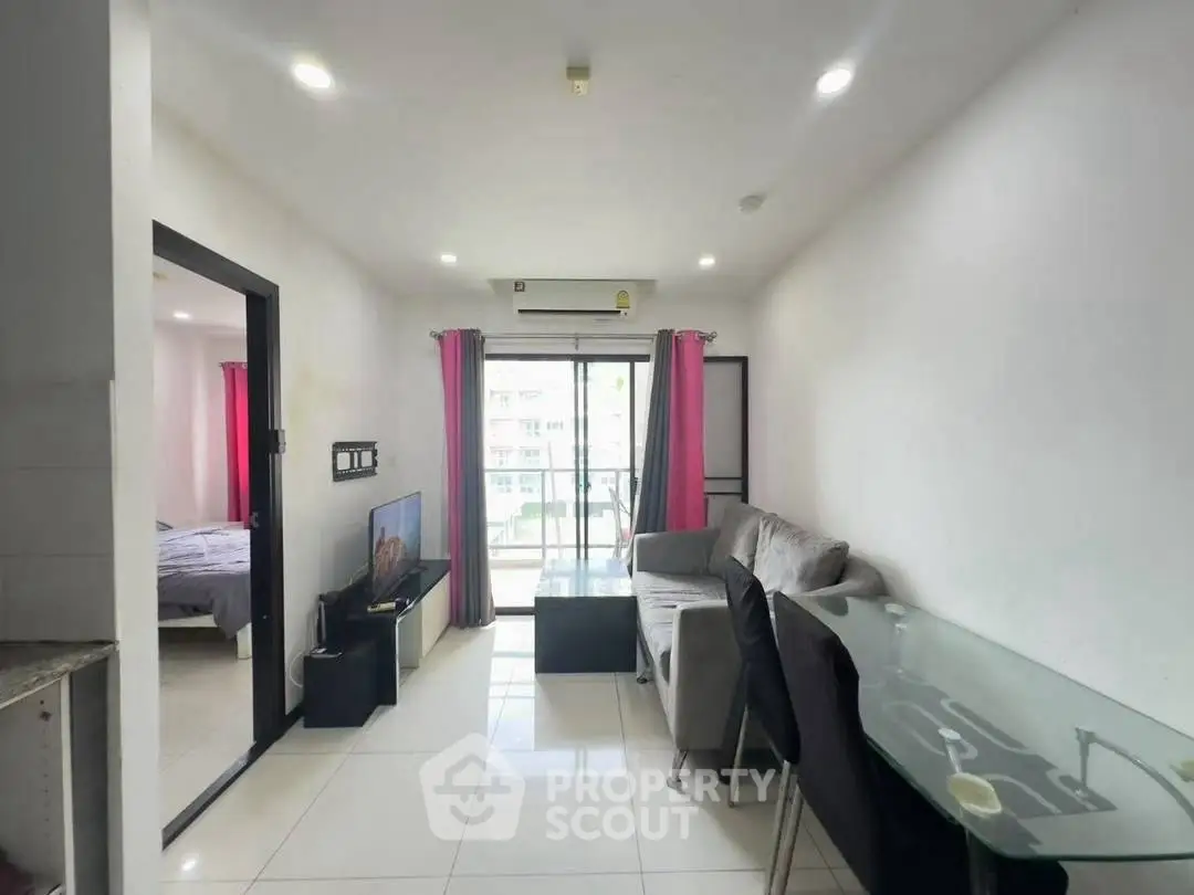 Modern living room with balcony, sleek furniture, and bright lighting in a stylish apartment.